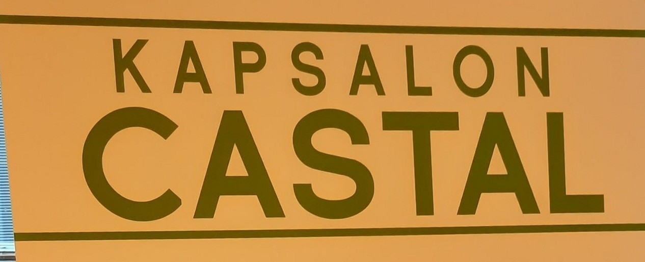 De naam KAPSALON CASTAL in olijfgroene letters op het raam van de zaak